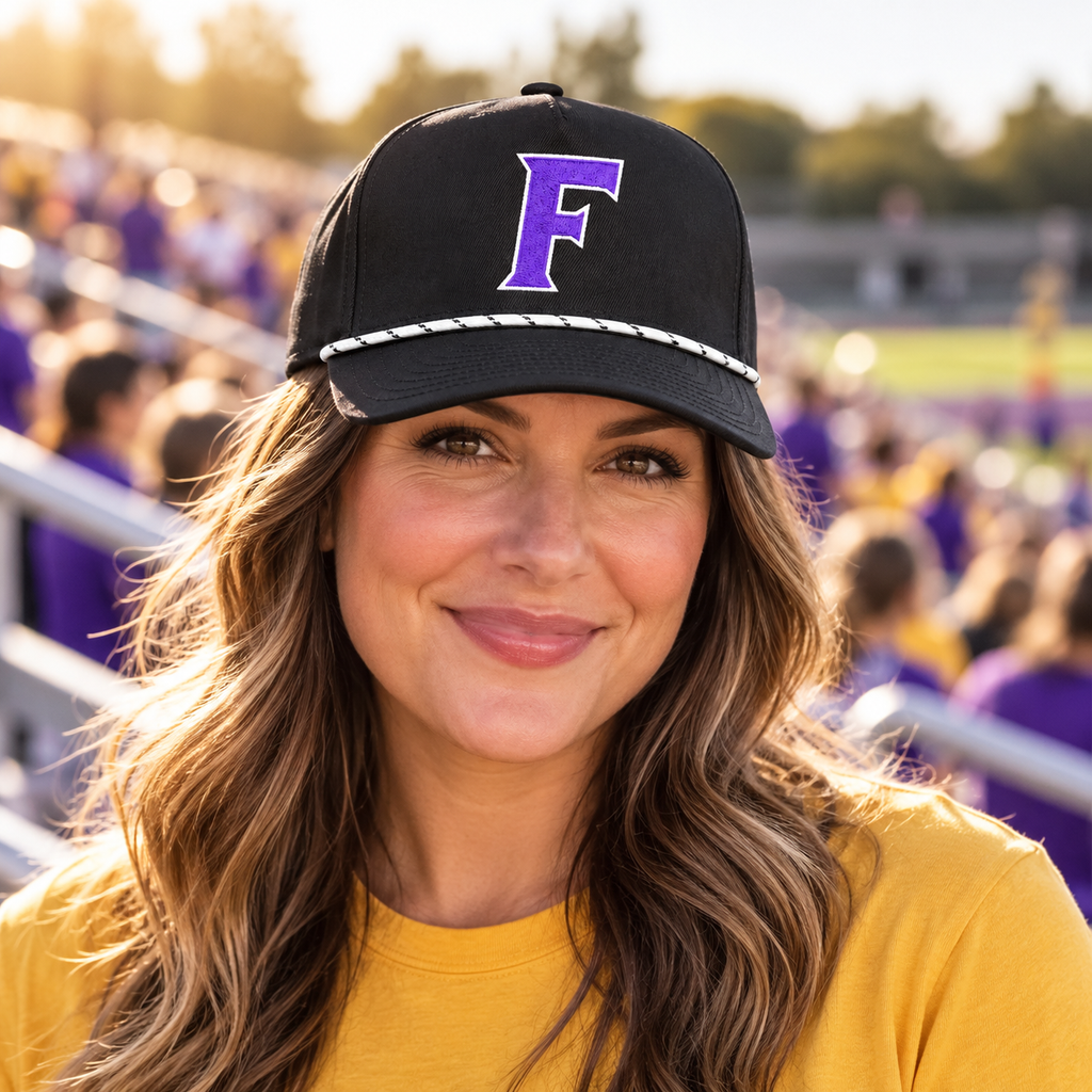 Adult fan wearing the Farmersville Luna F White Rope cap at a purple-and-gold game-day stadium — lifestyle mockup